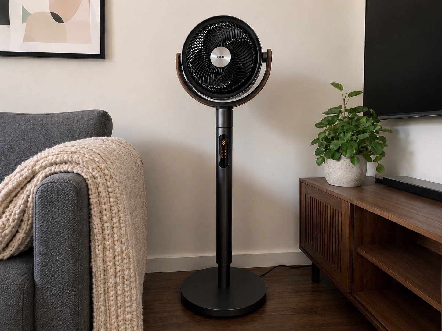 Dreo TurboPoly Fan 513S pedestal fan with dual oscillation and smart controls in a modern living room next to a wooden media console